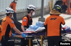 Emergency personnel carry the body of a person killed in a deadly fire at a lithium battery factory owned by South Korean battery maker Aricell, in Hwaseong, South Korea, June 24, 2024.