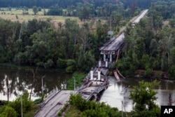 Un puente destruido sobre el río Siverskyi-Donets en la aldea liberada de Bogorodychne, Ucrania, el miércoles 12 de junio de 2024. (Foto AP/Evgeniy Maloletka)