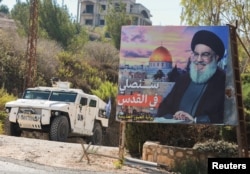 Kendaraan pasukan penjaga perdamaian PBB (UNIFIL) melaju di dekat gambar yang memperlihatkan pemimpin Hizbullah Lebanon Sayyed Hassan Nasrallah di Desa Adaisseh, dekat perbatasan Lebanon-Israel, Lebanon selatan, 11 Oktober 2022. (Foto: REUTERS/Aziz Taher)