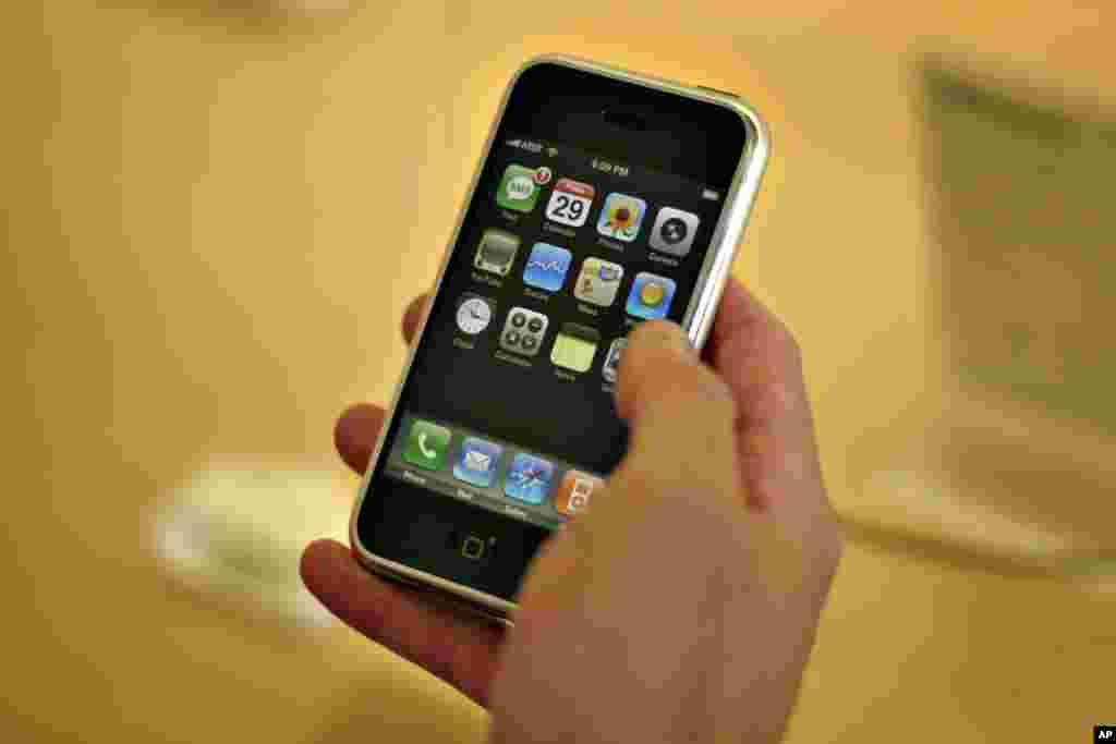 A customer tries an iPhone in an Apple store, in this June, 29, 2007 file photo, in Seattle. Apple Inc. is expected to release quarterly earnings on Wednesday, July 25, 2007.