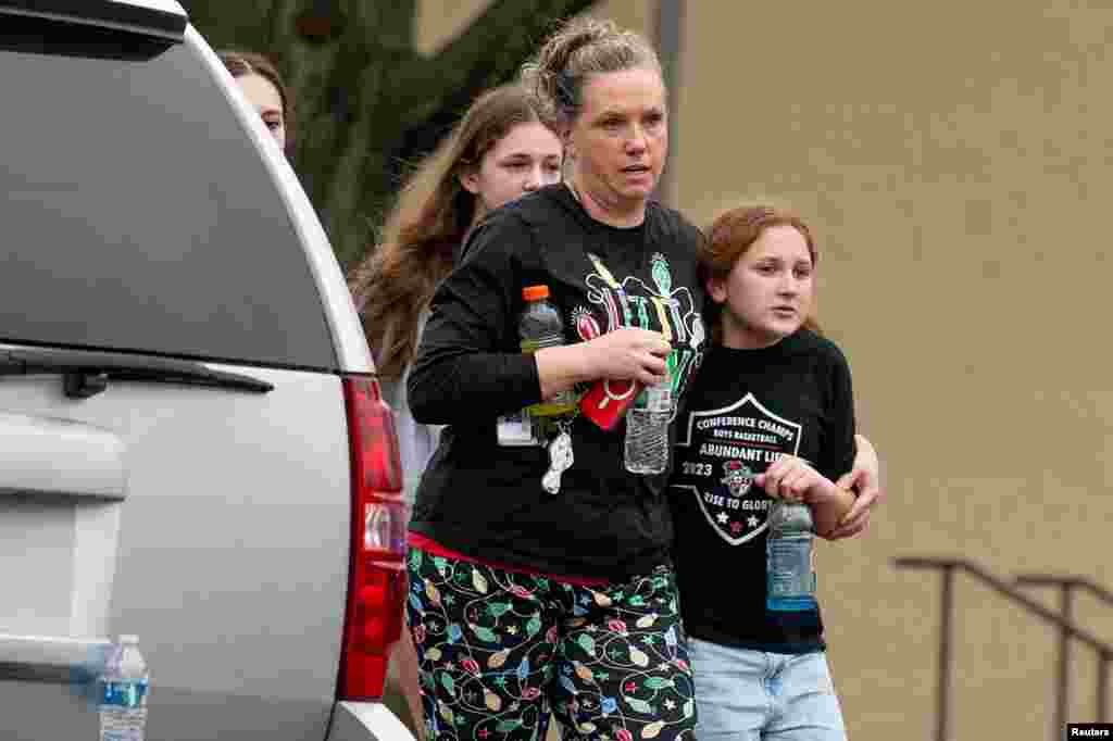 A family leaves the scene of a shooting at Abundant Life Christian School in Madison, Wisconsin, Dec. 16, 2024.