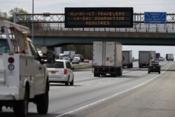 FILE - An electronic billboard orders travelers from New York, New Jersey and Connecticut to quarantine for 14 days if they travel away from home due during the coronavirus pandemic, in Elkridge, Maryland, April 14, 2020.