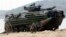 U.S. Marines jump off an amphibious assault vehicle after hitting the ground at a joint military exercise on Hat Yao beach in Chonburi province eastern, Thailand, February 10, 2012.