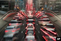 FILE - In this slow-shutter zoom effect photo taken Dec. 12, 2018, commuters are backed up in traffic during the morning rush hour in Brussels, a city that regularly experiences pollution alert warnings.