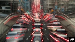 FILE - In this slow-shutter zoom effect photo taken Dec. 12, 2018, commuters are backed up in traffic during the morning rush hour in Brussels, a city that regularly experiences pollution alert warnings.