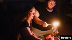 Christina Beverly dan John Shearon menyalakan lilin setelah cuaca musim dingin mengakibatkan listrik padam di Fort Worth, Texas, Sabtu, 20 Februari 2021. 