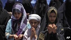 Yemeni children, chant prayers with female anti-government protesters, during a demonstration demanding the resignation of Yemeni President Ali Abdullah Saleh, in Sana'a, Yemen, May 19, 2011.