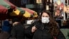 A woman who declined to give her name wears a mask, Jan. 30, 2020, in New York. She works for a pharmaceutical company and said she was concerned about coronavirus infection. "I'd wear a mask if I were you," she said. 
