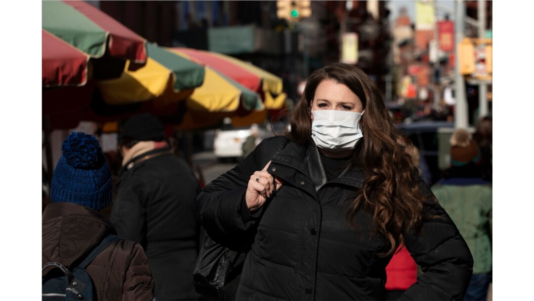A woman, who declined to give her name, wears a mask, Jan. 30, 2020, in New York. She works for a pharmaceutical company and said she wears the mask out of concern for the coronavirus.