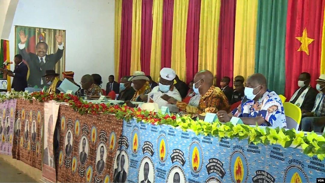 Supporters of Cameroon President Paul Biya, with a poster depicting Biya in the background, are seen gathered in Monatele, Nov. 6, 2021. (Moki Edwin Kindzeka/VOA)
