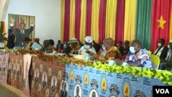 Supporters of Cameroon President Paul Biya, with a poster depicting Biya in the background, are seen gathered in Monatele, Nov. 6, 2021. (Moki Edwin Kindzeka/VOA)