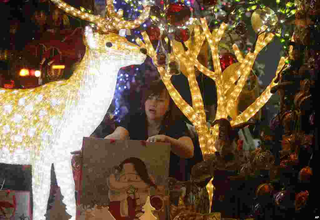 A woman decorates a Christmas shop window in Kyiv, Ukraine.