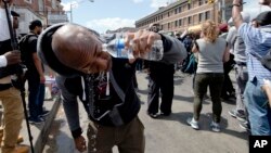 Un manifestante se limpia el rostro tras ser afectado por gas lacrimógeno durante una protesta en Baltimore.