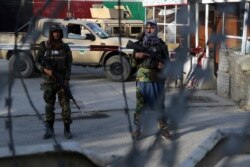 Taliban fighters stand guard at a checkpoint near the gate of Hamid Karzai international Airport in Kabul, Aug. 28, 2021.