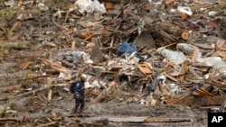 Rescue worker traverses massive debris pile at scene of deadly mudslide, Oso, Wash., March 27, 2014.