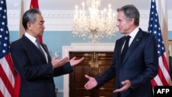 Menteri Luar Negeri AS Antony Blinken (kanan) berbincang dengan Menteri Luar Negeri China Wang Yi sebelum melangsungkan pertemuan di Kantor Departemen Luar Negeri AS di Washington, DC, pada 26 Oktober 2023. (Foto: AFP/Saul Loeb)