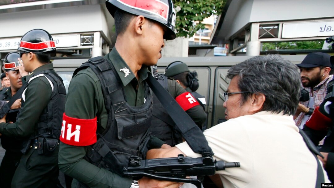 Seorang demonstran anti kekuasaan militer beradu fisik dengan tentara di Monumen Kemenangan di Bangkok (28/5). 