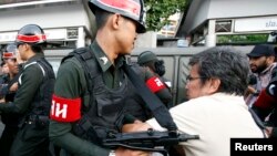 Seorang demonstran anti kekuasaan militer beradu fisik dengan tentara di Monumen Kemenangan di Bangkok (28/5). 