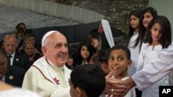 Paus Fransiskus bersalaman dengan anak-anak pengungsi Palestina di kamp Dheisheh dekat Bethlehem, Tepi Barat (25/5). (AP/Menahem Kahana)