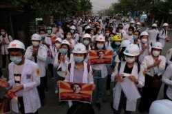 FILE - Medical staff and students take part in a protest against the military coup and crackdown by security forces on demonstrations in Mandalay, March 21, 2021.