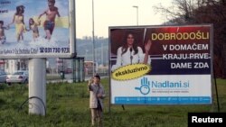 A man takes a selfie in front of placard with a picture of Melania Trump in her hometown Sevnica, Slovenia, Dec. 1, 2016. Banner reads 'Welcome in hometown of first lady of U.S.' 