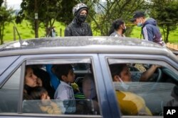 A family sits in their car at a roadblock set up by anti-government protesters in Madrid, on the outskirts of Bogota, Colombia, May 28, 2021.