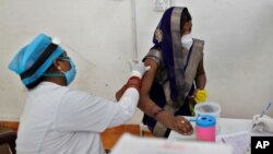 Seorang perempuan menerima suntikan vaksin AstraZeneca di sebuah rumah sakit di Prayagraj, India (1/5). 