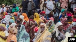 Families wait outside the port of Pemba on April 1, 2021, for the boat of evacuees from Palma.