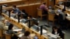 FILE - People work on laptops in a reading room at the British Library in London, June 20, 2011. 