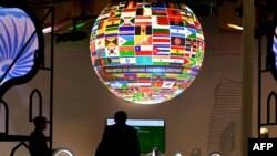 Visitors walk past a sphere featuring flags of countries of the world displayed at the pavillion of India on Nov. 8, 2017, during the COP23 U.N. Climate Change Conference in Bonn, Germany.