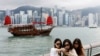 FILE - Tourists take photos in front of Victoria Harbour, in Tsim Sha Tsui, in Hong Kong, China April 29, 2024.