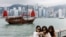 FILE - Tourists take photos in front of Victoria Harbour, in Tsim Sha Tsui, in Hong Kong, China April 29, 2024.