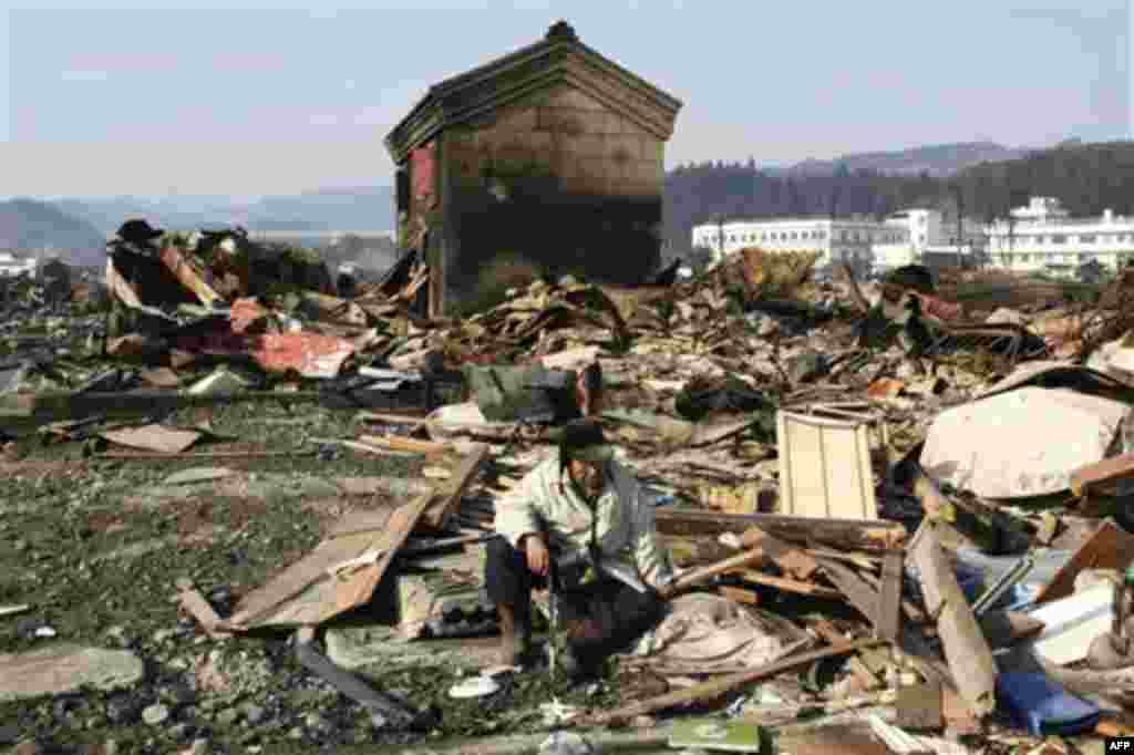 A tsunami survivor sits down in the rubble in Yamadamachi in Iwate Prefecture Monday, March 14, 2011, three days after a powerful earthquake-triggered tsunami hit the country's east coast. (AP Photo/The Yomiuri Shimbun, Takashi Ozaki) JAPAN OUT, CREDIT MA