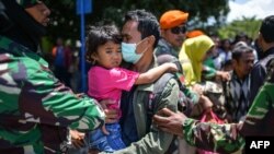 Warga berjalan menuju pesawat militer untuk evakuasi di Bandara Mutiara SIS Al-Jufrie di Palu, 6 Oktober 2018.