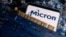 FILE - A smartphone with a displayed Micron logo is placed on a computer motherboard in this illustration taken March 6, 2023.