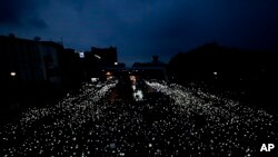 Pro-democracy activists wave mobile phones with lights during a demonstration at Kaset intersection, in Bangkok, Thailand.