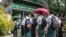 Students wait outside a school entrance in Sittwe, capital of western Rakhine State on June 1, 2021. - Schools in Myanmar opened on June 1 for the first time since the military seized power, but teachers and students are set to defy the junta's calls for 