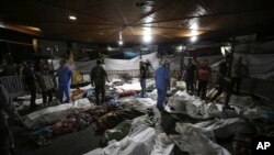 Jenazah warga Palestina yang tewas akibat ledakan di rumah sakit Ahli Arab berkumpul di halaman depan rumah sakit al-Shifa, di Kota Gaza, Jalur Gaza tengah, Selasa, 17 Oktober 2023. (Foto: AP)