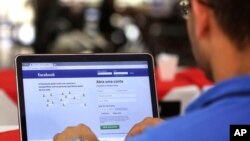 FILE - A man enters his Facebook page at a restaurant in Brasilia, Brazil, Jan. 4, 2018.