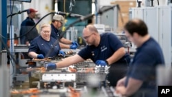 FILE - Employees work in the battery assembly hall at the BMW Spartanburg plant in Greer, South Carolina, on Oct. 19, 2022. Statistics released on Dec. 6, 2024, show the United States added 227,000 jobs in November.