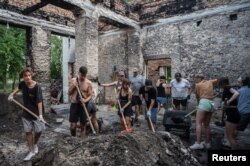 Volunteers clean up the House of a Culture in the village of Yahidne