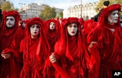 FILE - Protesters from the group Extinction Rebellion walk to Hyde Park in London, April 25, 2019.