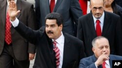 Venezuela's Vice President Nicolas Maduro, left, and Diosdado Cabello, president of Venezuela's National Assembly, gesture to supporters as they arrive at the National Assembly for the state-of-the-nation address in Caracas, Feb. 28, 2013. 