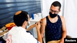An Israeli man receives a third shot of coronavirus disease (COVID-19) vaccine in Tel Aviv, Israel, Aug. 30, 2021. 