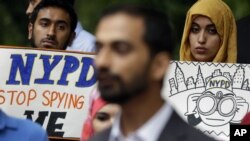 People hold signs while attending a rally to protest New York Police Department surveillance tactics near police headquarters in New York, Aug. 28, 2013. An audit conducted by Inspector General Philip Eure, found that New York Police Department chronically skirted rules intended to protect political groups from unwarranted government surveillance while investigating Muslims. The results of the audit released Tuesday, Aug. 23, 2016 went on to state that while the NYPD's Intelligence Division had valid reasons to launch investigations, it frequently extended them past court-mandated deadlines without proper authorization.