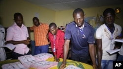 Electoral officials sort out ballot papers at the end of presidential elections in Conakry, Guinea, Oct. 11, 2015. 