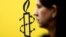 La militante des droits des femmes, Luisa Kislinger, devant le logo d'Amnesty International à Caracas au Venezuela le 20 février 2019.