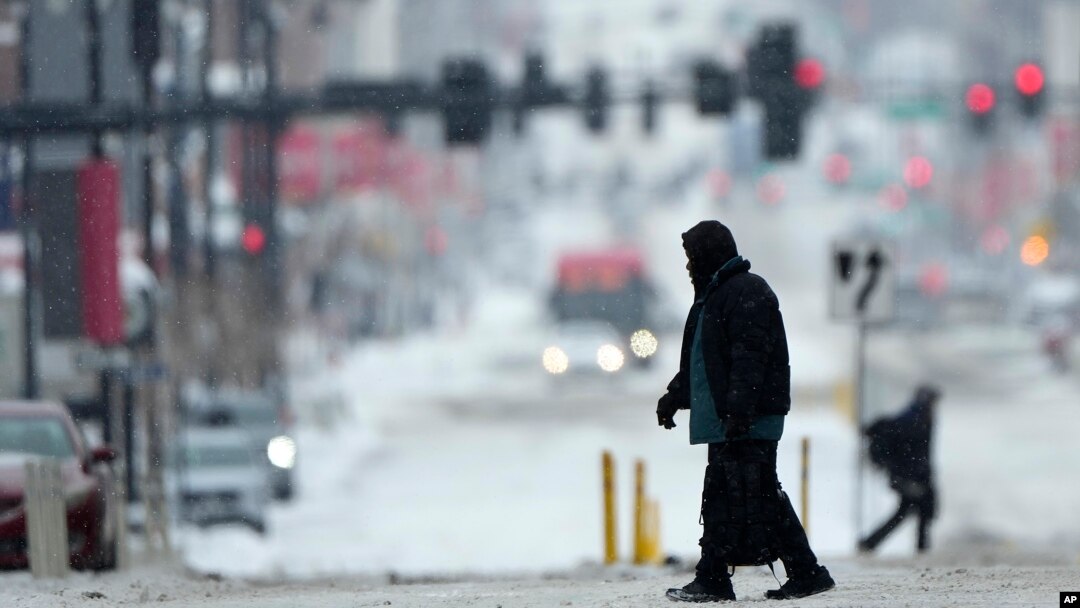 Seorang warga tampak menyeberang di jalanan yang diselimuti salju di pusat kota Kansas City, Missouri, di saat badai musim dingin melintasi wilayah tersebut pada 12 Februari 2025. (Foto: AP/Charlie Riedel)
