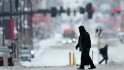 Seorang warga tampak menyeberang di jalanan yang diselimuti salju di pusat kota Kansas City, Missouri, di saat badai musim dingin melintasi wilayah tersebut pada 12 Februari 2025. (Foto: AP/Charlie Riedel)