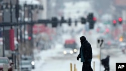 Los peatones cruzan una calle nevada en el centro de Kansas City, Missouri, mientras una tormenta invernal pasaba por el área el 12 de febrero de 2025. [Foto: AP]